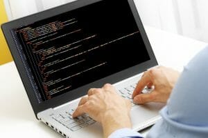 writing programming code on laptop